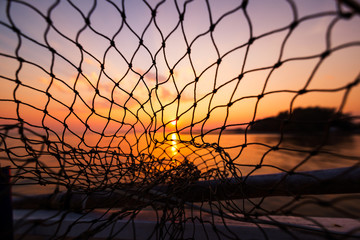 dip net in boat fishing on sunrise, sunset water.
