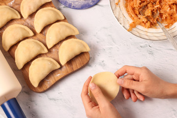 Cooking dumplings with cabbage at home, Traditional dish of Ukrainian cuisine, The dough in female hands