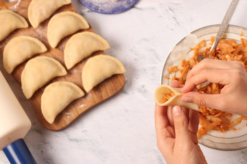 Cooking dumplings with cabbage at home, Traditional dish of Ukrainian cuisine, The dough in female hands