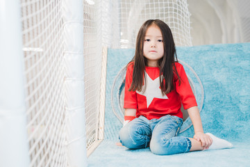 Pretty little Asian girl with long hair wearing costume of super girl