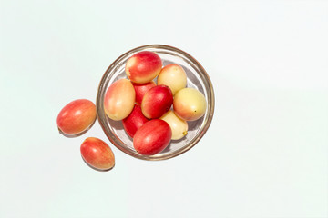 Fresh and organic colorful Indian red Carissa carandas or carandas plum fruit on a glass bowl.