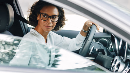 Young female entrepreneur driving a car looking away