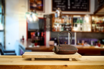 Kettle on wooden board and cafe interior.Free space for your decoration. 