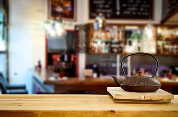 Kettle on wooden board and cafe interior.Free space for your decoration. 