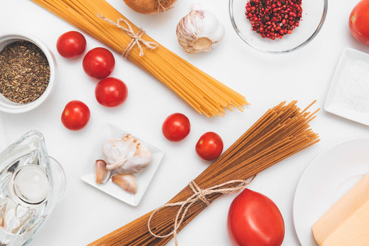 spaghetti, pasta, tomatoes, cheese, pepper, garlic on white background, raw pasta,