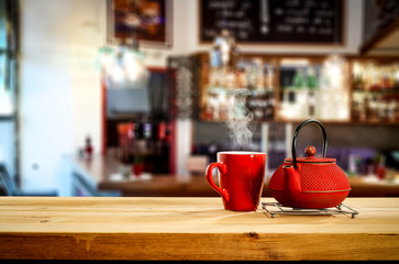 Kettle on wooden board and cafe interior.Free space for your decoration. 