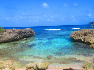 Une baie entourée  de rocher avec la mer turquoise