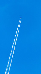 Two engined airplane during flight in high altitude with condensation trails