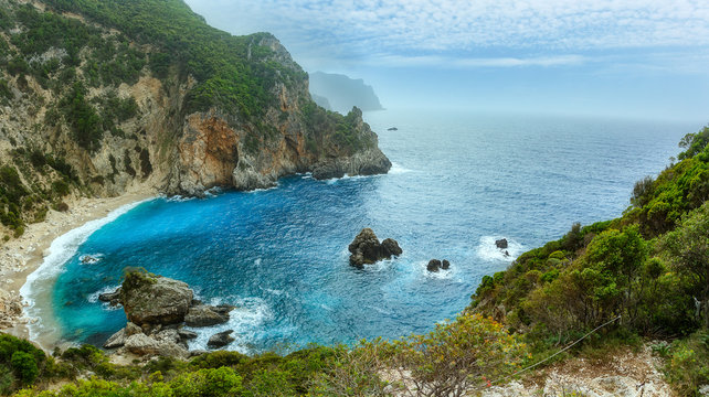  Beautiful view over the sea beach in Kerkyra island. Wonderful morning seascape of Ionian Sea, Corfu island. Aerial summer view of Giali Beach. Greece, Europe. Awesome nature landscape