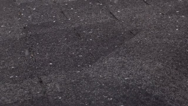 Close up Snow Falling on Dark Roof Shingles