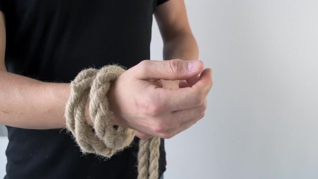 MMn shows how to tie reef knots on hand. Close up