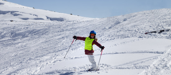 Fototapeta na wymiar Little skier on ski slope with new fallen snow at sun day