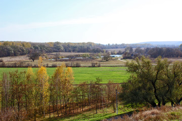 Autumn landscape with fields, trees and hills.