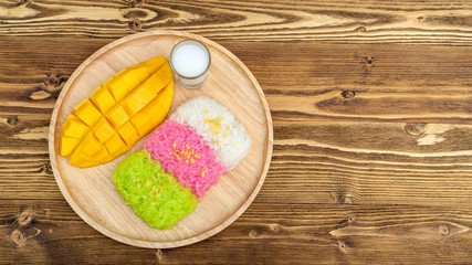 Three colors of sticky rice and ripe mango (Thai dessert).