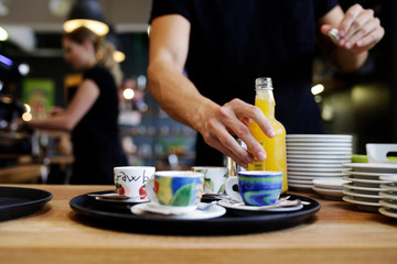 The waiter prepares an order for customers - coffee and juice.