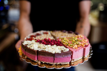 Young man holding different kind of cheesecakes. 