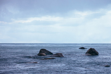 Fototapeta premium panoramic view of the sea coast with stones and thunderclouds