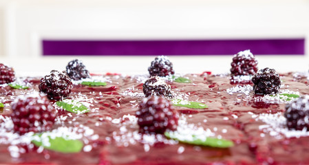 Turkish Traditional Dairy Dessert Cake With raspberries. Delicious milky dessert decorated with coconut and mint leaves selective focus.
