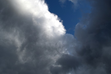 Clouds are almost black against a bright blue sky before a strong thunderstorm