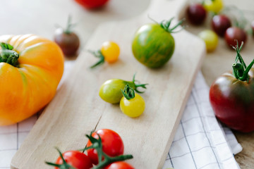 Different variety of tomatoes on wooden background. 