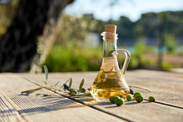 olive oil with fresh olives and leaves