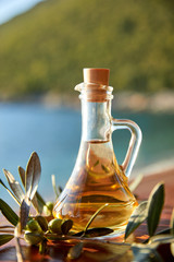 olive oil with fresh olives and leaves