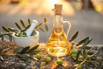 olive oil with fresh olives and leaves