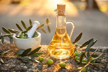 olive oil with fresh olives and leaves