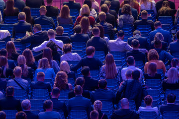 Business conference attendees sit and listen