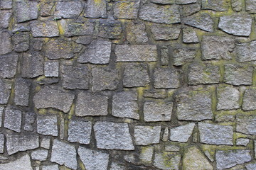 The texture of the stone walls of the old city of Europe, bricks made of granite and stones.