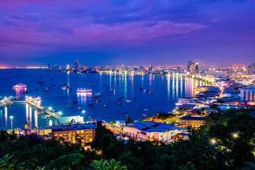 High view on viewpoint see cityscape with colorful light at the beach and the sea of ​​Pattaya Bay, beautiful landscape of Pattaya City at night scene landmark in Chonburi, Travel Asia to Thailand - obrazy, fototapety, plakaty
