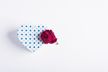 blue polka dot heart-shaped cardboard box next to pink with almost dry petals