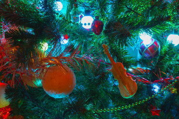 Christmas background with the spruce branch, golden sparkling balls, and stars on the background. Christmas lights garland.