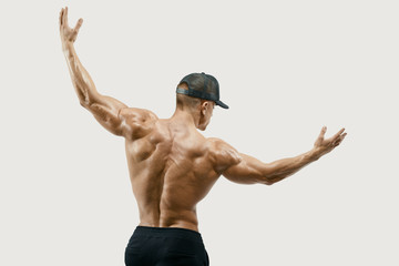 Shot of healthy muscular young man turning back and rise both hands. Perfect fit, abdominal muscle, shoulders, deltoids, biceps. Clipping mask path White background.