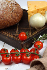 A set of products from fresh, crisp bread, cheese, onions and cherry tomatoes on the table before cooking