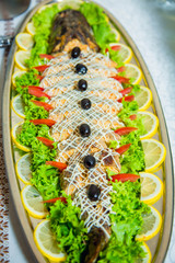 stuffed pike decorated with slices of lemon and butter cream