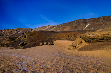Fumarole fields of Iceland covered with yellow brimstone with boiling mud craters against the winter sky