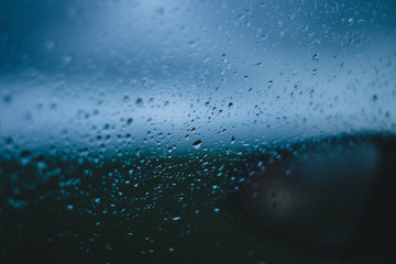 view on blurred flower field and mirror in drops from the car window