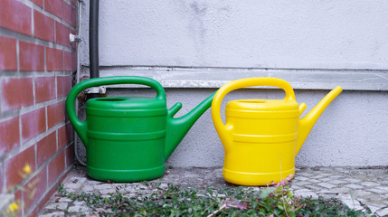green and yellow watering cans