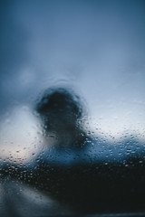 blurred tree and clouds through the window in drops
