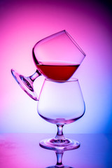 Two glass glasses on a colored background