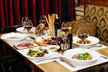 served table in the restaurant for a banquet with appetizers, salads and wine