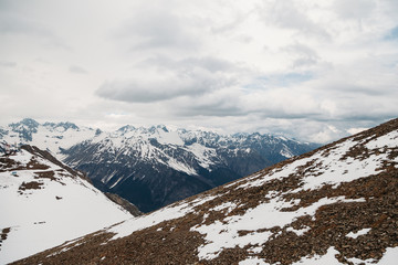 Views of high snow-capped mountain peaks are covered with fluffy white clouds