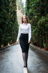 Young business woman in skirt posing outdoors in the rain
