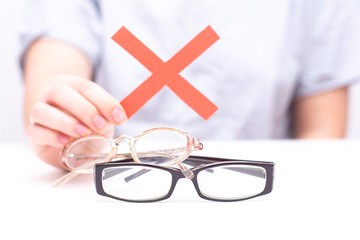 Refusal of glasses for sight. hands refuse glasses. cross on glasses. Vision improvement, laser vision correction.