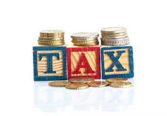 Tax Concept with wooden block on stacked coins,isolated white