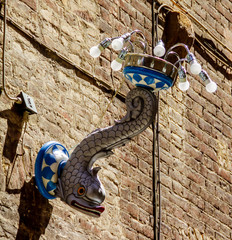 Coat of arms lamp of the captain's counter "Wave" ("Onda") - ​​a swimming dolphin in the royal crown. Siena, Italy.