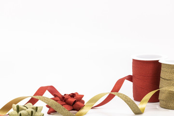 Bobines de bolduc rouge et doré à paillettes déroulées pour faire les cadeaux de noël ou pour...