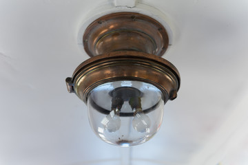 Antique ceiling light fitting in a restored railway carriage.