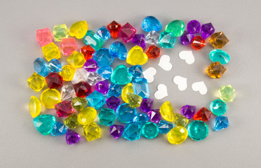 White paper heart and gems on gray background